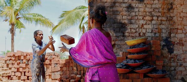 Indian labourers work at a brick manufacturing factory situated on the outskirts of Bangalore on June 3, 2017. - Sputnik Afrique