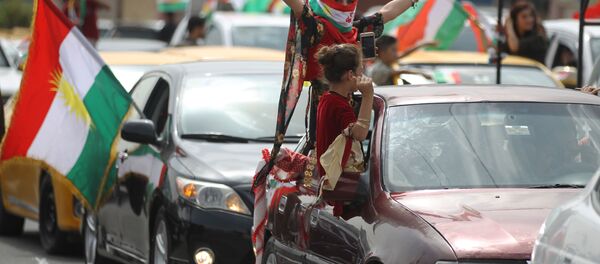 Девушка с курдским флагом на лице на улице города Киркук в Ираке во время референдума - Sputnik Afrique