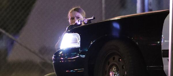 A police officer takes cover behind a police vehicle during a shooting near the Mandalay Bay resort and casino on the Las Vegas Strip, Sunday, Oct. 1, 2017, in Las Vegas - Sputnik Afrique