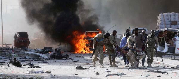 Somali Armed Forces evacuate their injured colleague, from the scene of an explosion in KM4 street in the Hodan district of Mogadishu, Somalia October 14, 2017. - Sputnik Afrique