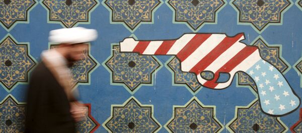 Иранский священнослужитель проходит мимо росписи на стене бывшего посольства США в Тегеране Иранский священнослужитель проходит мимо росписи на стене бывшего посольства США в Тегеране - Sputnik Afrique