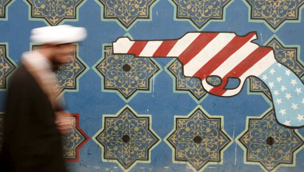 Иранский священнослужитель проходит мимо росписи на стене бывшего посольства США в Тегеране - Sputnik Afrique