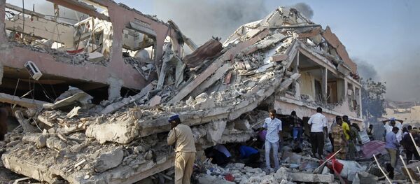 Somalis gather and search for survivors by destroyed buildings at the scene of a blast in the capital Mogadishu, Somalia Saturday, Oct. 14, 2017. - Sputnik Afrique