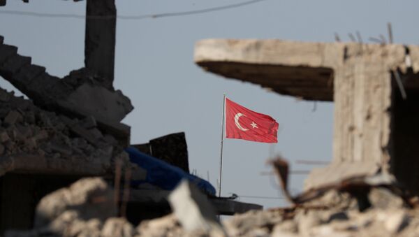 Turkish flag flutters at Turkey's border gate, as pictured on Syria side, overlooking the ruins of buildings destroyed during fightings with the Islamic State militants in Kobani, Syria October 11, 2017. - Sputnik Afrique