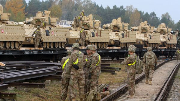 Members of the US Army 1st Brigade, 1st Cavalry Division, unload heavy combat equipment including Bradley Fighting Vehicles at the railway station near the Rukla military base in Lithuania, on October 4, 2014 - Sputnik Afrique