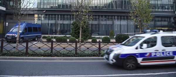 The headquarters of France's Anti-Terrorism Sub-Directorate (Sous Direction de la Lutte Anti-Terroriste, SDAT) is reflected onto a glass building as a police car drives past on November 15, 2015 - Sputnik Afrique