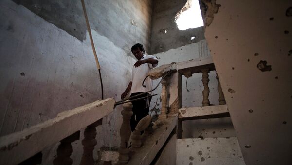 Un Libyen dans une maison endommagée par un bombardement à Syrte - Sputnik Afrique