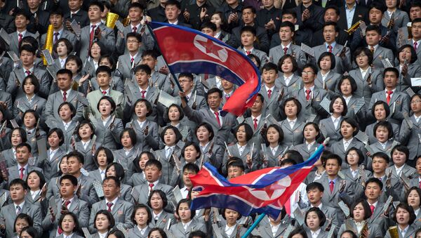 Северокорейцы размахивают флагом в поддержку своей команды во время соревнований по футболу - Sputnik Afrique