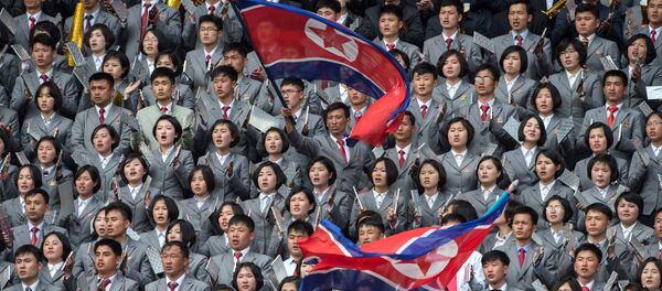 Северокорейцы размахивают флагом в поддержку своей команды во время соревнований по футболу - Sputnik Afrique