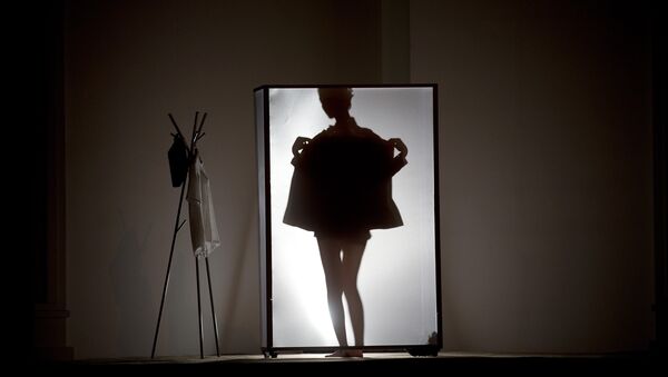A model is silhouetted on stage as she prepares to present La Nouvelle Famille home wear collections by Chinese designer Ma Bin during China Fashion Week in Beijing Thursday, Oct. 31, 2013. - Sputnik Afrique
