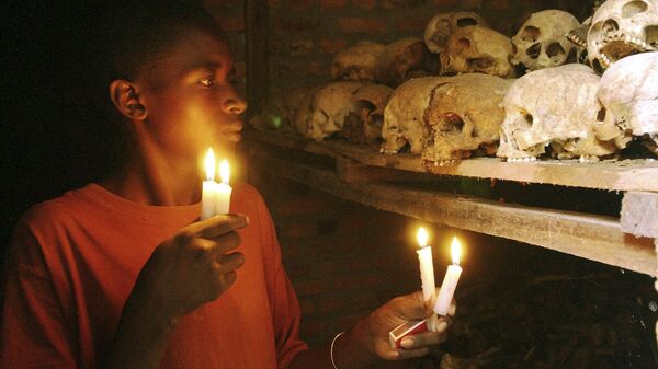 Un survivant du génocide rwandais allume des bougies devant des restes de victimes - Sputnik Afrique