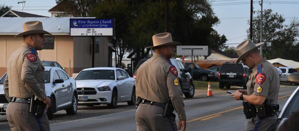 State troopers patrol at the entrance to the First Baptist Church (back) after a mass shooting that killed 26 people in Sutherland Springs, Texas on November 6, 2017 State troopers patrol at the entrance to the First Baptist Church (back) after a mass shooting that killed 26 people in Sutherland Springs, Texas on November 6, 2017 - Sputnik Afrique