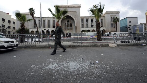 Сотрудник сирийской службы безопасности около места взрыва в Дамаске - Sputnik Afrique