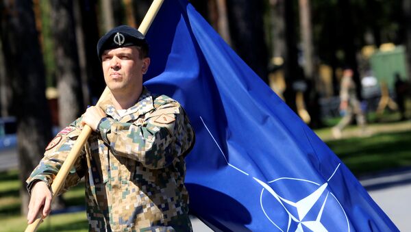 A Latvian Army soldier walks with the NATO flag during the official welcoming ceremony of the NATO Canadian-led Enhanced Forward Presence (EFP) combat battalion in Adazi, Latvia June 19, 2017 - Sputnik Afrique