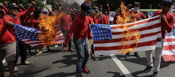 les manifestants brûlent un drapeau américain à Manille - Sputnik Afrique
