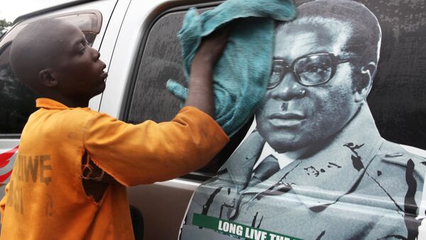 Youth washes a minibus adorned with picture of President Robert Mugabe at a bus terminus in Harare, Zimbabwe, November 15, 2017 - Sputnik Afrique
