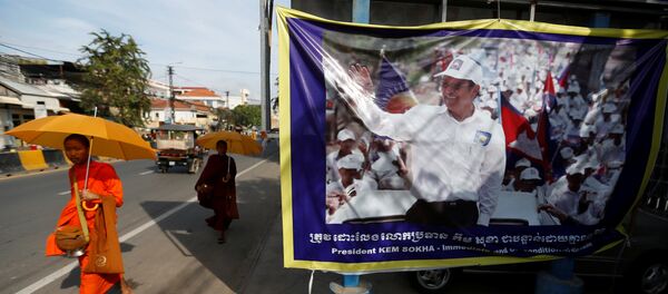 Buddhist monks walk past a banner of opposition leader and President of the Cambodia National Rescue Party (CNRP) Kem Sokha at the party's headquarters in Phnom Penh, Cambodia, November 17, 2017. - Sputnik Afrique