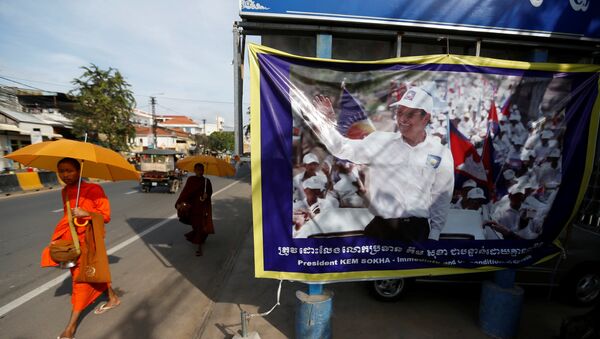 Buddhist monks walk past a banner of opposition leader and President of the Cambodia National Rescue Party (CNRP) Kem Sokha at the party's headquarters in Phnom Penh, Cambodia, November 17, 2017. - Sputnik Afrique