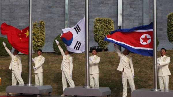 The flags of South Korea (C), China (L) and North Korea (File) - Sputnik Afrique