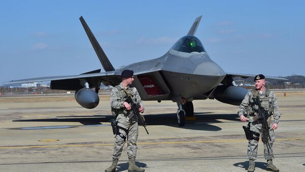 US soldiers stand guard near a US F-22 stealth fighter at the Osan Air Base in Pyeongtaek, south of Seoul, on February 17, 2016. - Sputnik Afrique