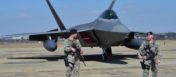 US soldiers stand guard near a US F-22 stealth fighter at the Osan Air Base in Pyeongtaek, south of Seoul, on February 17, 2016. - Sputnik Afrique