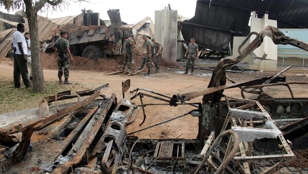 French soldiers clean debris around a destroyed armoured vehicle, 10 November 2004 at Descartes lycee in Bouake which served as a camp for French soldiers. - Sputnik Afrique