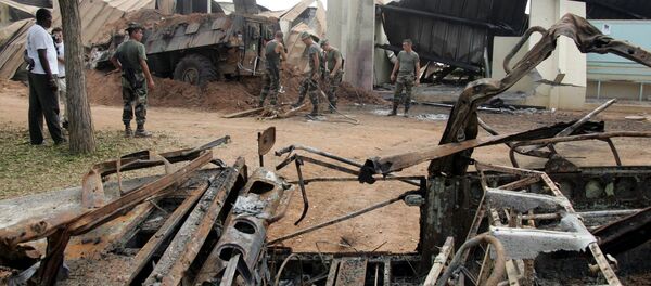 French soldiers clean debris around a destroyed armoured vehicle, 10 November 2004 at Descartes lycee in Bouake which served as a camp for French soldiers. - Sputnik Afrique