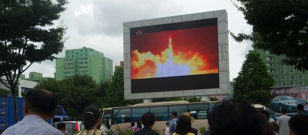 People watch as coverage of an ICBM missile test is displayed on a screen in a public square in Pyongyang on July 29, 2017. People watch as coverage of an ICBM missile test is displayed on a screen in a public square in Pyongyang on July 29, 2017. - Sputnik Afrique