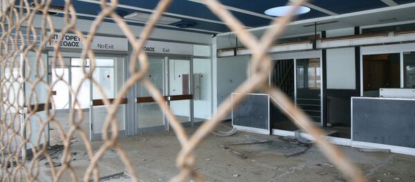 Shattred glass litters the floor in front of check-in counters at the decaying Nicosia International Airport, on March 17, 2009. - Sputnik Afrique