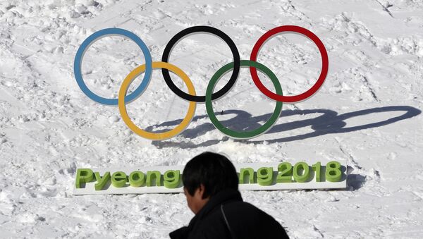 In this Feb. 3, 2017 photo, a man walks by the Olympic rings with a sign of 2018 Pyeongchang Olympic and Paralympic Winter Games in Pyeongchang, South Korea - Sputnik Afrique