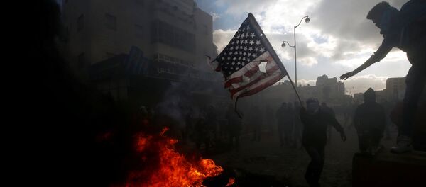 Палестинцы жгут американский флаг во время столкновений с израильской полицией в связи с протестами против решения Дональда Трампа признать Иерусалим столицей Израиля Палестинцы жгут американский флаг во время столкновений с израильской полицией в связи с протестами против решения Дональда Трампа признать Иерусалим столицей Израиля - Sputnik Afrique