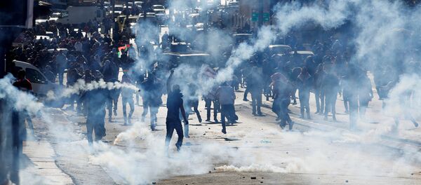 Palestinian demonstrators react to tear gas fired by Israeli troops during clashes at a protest against U.S. Palestinian demonstrators react to tear gas fired by Israeli troops during clashes at a protest against U.S. - Sputnik Afrique