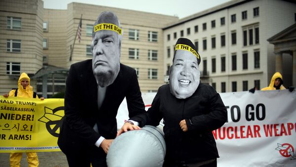 Activists of the non-governmental organization International Campaign to Abolish Nuclear Weapons (ICAN) wear masks of US President Donal Trump and leader of the Democratic People's Republic of Korea Kim Jon-un while posing with a mock missile in front of the embassy of Democratic People's Republic of Korea in Berlin, on September 13, 2017 - Sputnik Afrique
