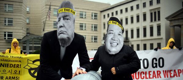 Activists of the non-governmental organization International Campaign to Abolish Nuclear Weapons (ICAN) wear masks of US President Donal Trump and leader of the Democratic People's Republic of Korea Kim Jon-un while posing with a mock missile in front of the embassy of Democratic People's Republic of Korea in Berlin, on September 13, 2017 - Sputnik Afrique