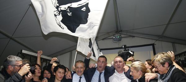 Candidates for the Pe a Corsica nationalist party Jean Guy Talamoni (4L) and Gilles Simeoni (4R) celebrate with supporters after the annoucement of the results in the territorial elections in Bastia on the French Mediterranean Island of Corsica on December 10, 2017. - Sputnik Afrique