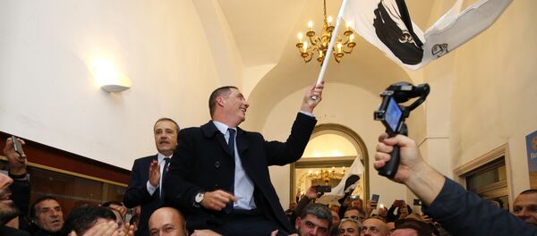 Candidates for the Pe a Corsica nationalist party for the Corsican territorial election Gilles Simeoni (C) and Jean Guy Talamoni (L) celebrate the results outside a polling station in Bastia on December 10, 2017 on the French Mediterranean Island of Corsica. - Sputnik Afrique