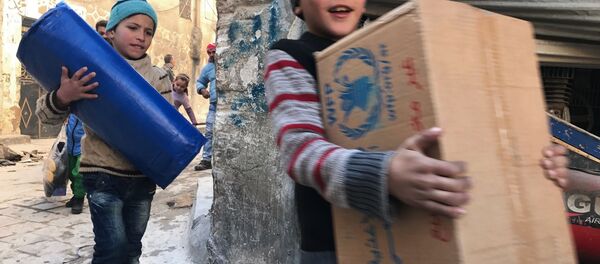 Des enfants reçoivent de l'aide humanitaire à Alep - Sputnik Afrique