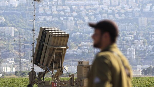 Un soldat israélien devant une batterie du système Dôme de fer - Sputnik Afrique