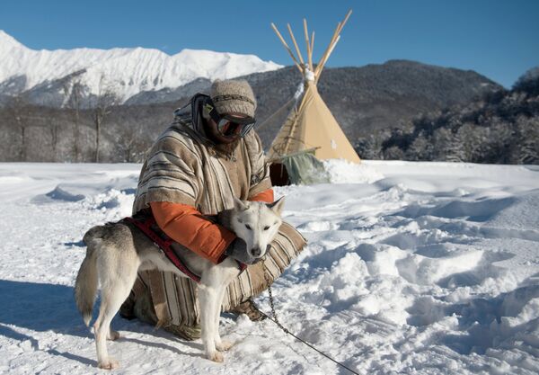 Un maître-chien avec son husky de Sibérie dans l’Husky-camping à la station de ski alpin de Roza-Khoutor, à Krasnaïa Poliana - Sputnik Afrique