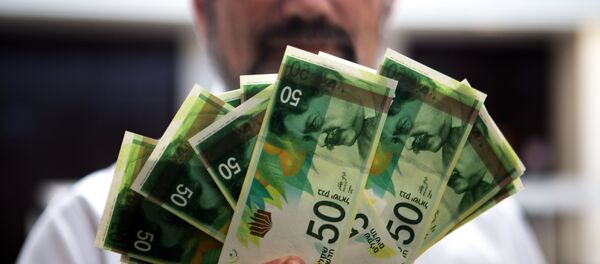 An employee of Bank of Israel holds new 50 Shekels' bills during a press conference at the bank's headquarters in Jerusalem on September 10 2014 - Sputnik Afrique