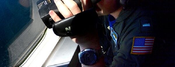 A member of the US Navy, aboard the Boeing P-8A Poseidon plane, looks down as they fly over the South Atlantic Ocean during the search for the ARA San Juan submarine missing at sea, Argentina November 26, 2017. - Sputnik Afrique