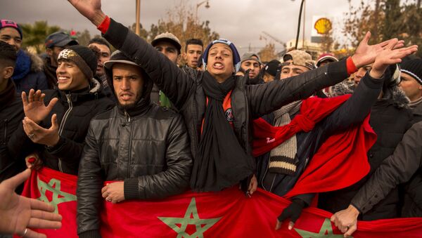Moroccans shout slogans and wave their national flag as they participate in a demonstration after the funeral of two brothers who died while digging in an abandoned coal mine in the northeastern city of Jerada, 60 kilometres southwest of Oujda, on December 27, 2017. - Sputnik Afrique