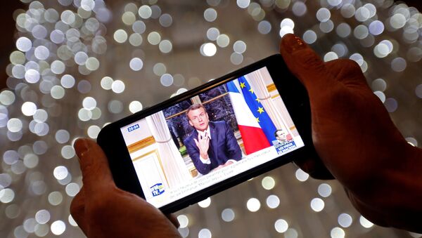 French President Emmanuel Macron is seen on the screen of an iPhone in Marseille as he gives the traditional New Year speech - Sputnik Afrique