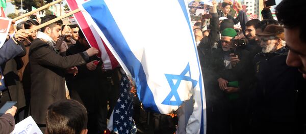 Des manifestants pro-gouvernementaux iraniens brûlent des drapeaux américain et israélien - Sputnik Afrique