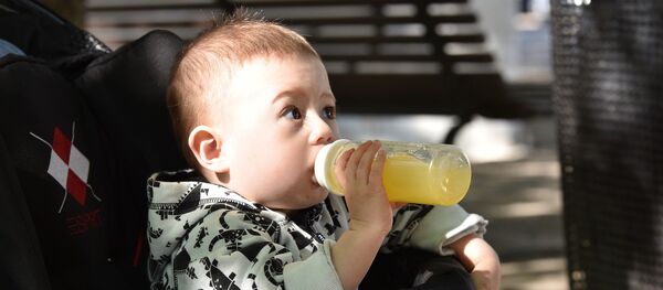 Ein Baby trinkt Orangensaft Ein Baby trinkt Orangensaft - Sputnik Afrique