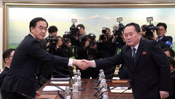 Head of the North Korean delegation, Ri Son Gwon shakes hands with South Korean counterpart Cho Myoung-gyon as they exchange documents after their meeting at the truce village of Panmunjom in the demilitarised zone separating the two Koreas, South Korea, January 9, 2018. - Sputnik Afrique