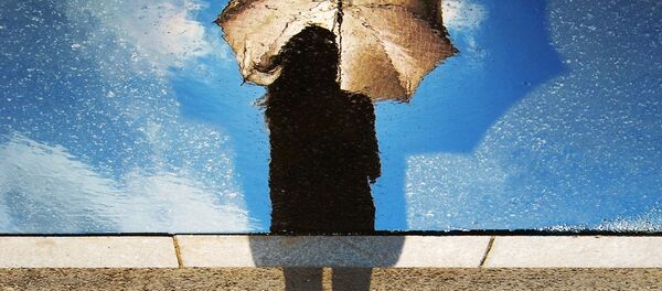 A silhouette of a woman holding an umbrella A silhouette of a woman holding an umbrella - Sputnik Afrique