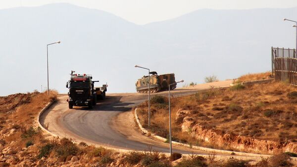 A picture taken on October 11, 2017, from the Syrian village of Atme in the northwestern province of Idlib shows Turkish military vehicles driving around a military base on the Turkish side of the border with Syria. - Sputnik Afrique