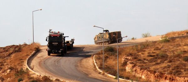 A picture taken on October 11, 2017, from the Syrian village of Atme in the northwestern province of Idlib shows Turkish military vehicles driving around a military base on the Turkish side of the border with Syria. - Sputnik Afrique