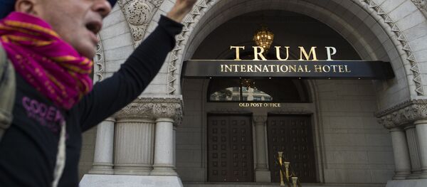Protesters shout slogans and hold up signs near the Trump Hotel as he takes part in the march for Racial Justice in Washington, DC, on September 30, 2017. - Sputnik Afrique
